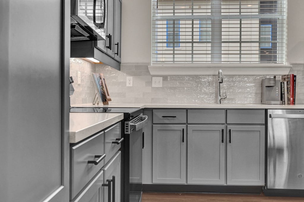 A modern kitchen with stainless steel appliances and a subway tile backsplash at West Row Lofts and Townhomes in Birmingham, AL